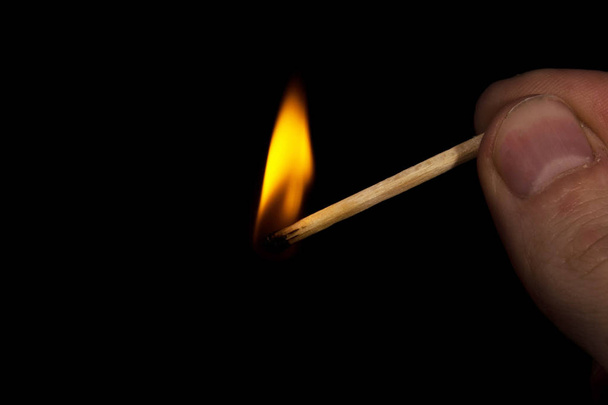 plamen hořící zápalky ženoucí se k prstům, které ji držely - Fotografie, Obrázek