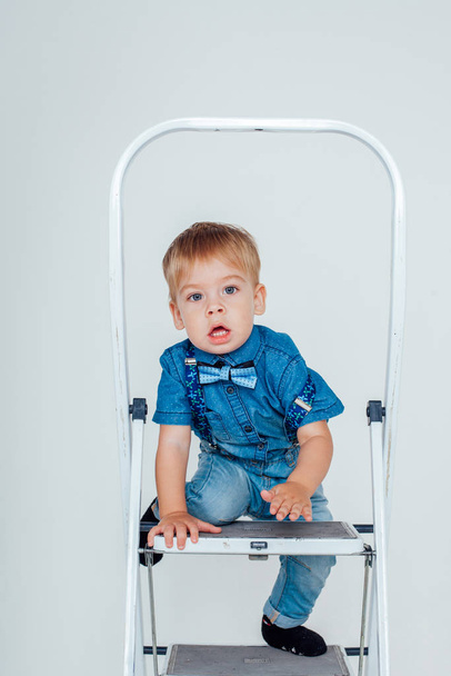 boy in a suit sitting on a stepladder - Photo, Image