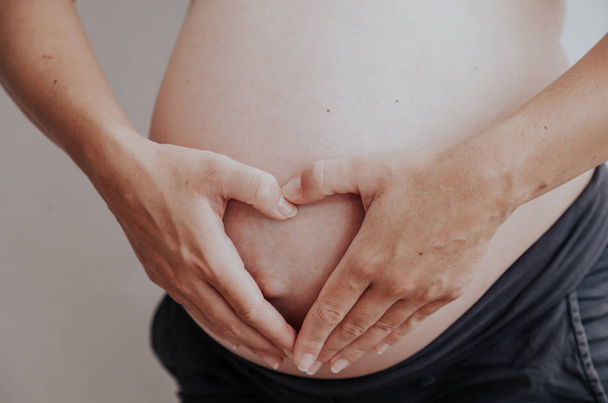 bir hamile kadın ve eller mutluluk kalp mide - Fotoğraf, Görsel