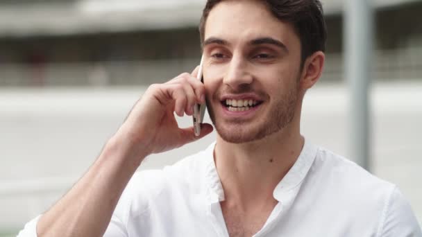Portrait of happy businessman having talk on mobile phone outside - Séquence, vidéo