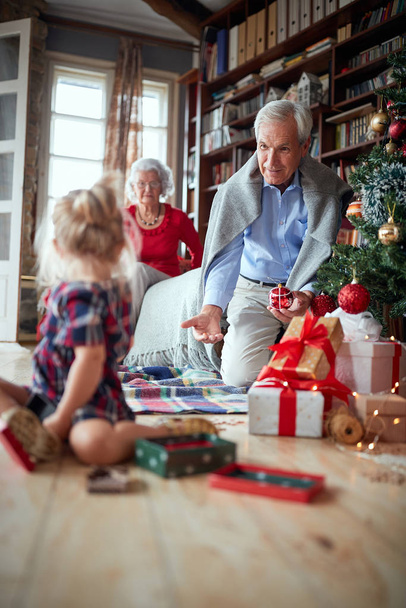Grandfather holding a Christmas tree decoration  - Photo, image