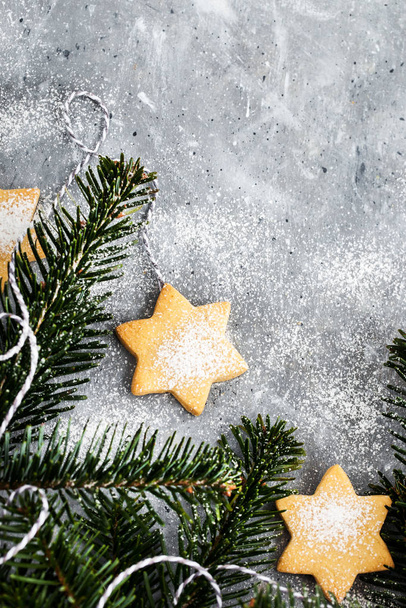 Chrismtas cookie stars and fir tree branches on gray background, - Fotó, kép