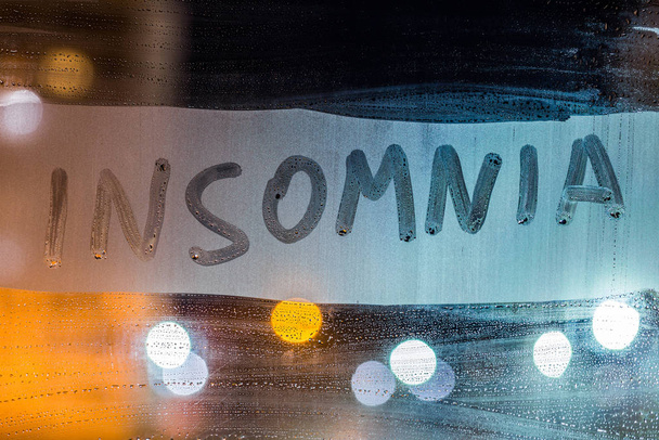 a palavra insônia escrito na noite molhado janela de vidro close-up com fundo borrado - Foto, Imagem