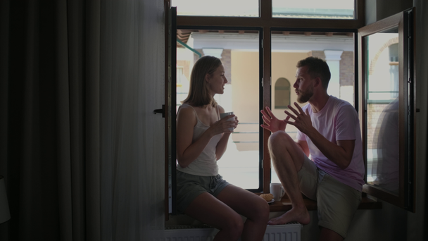 Couple having breakfast and talking by the window - Footage, Video