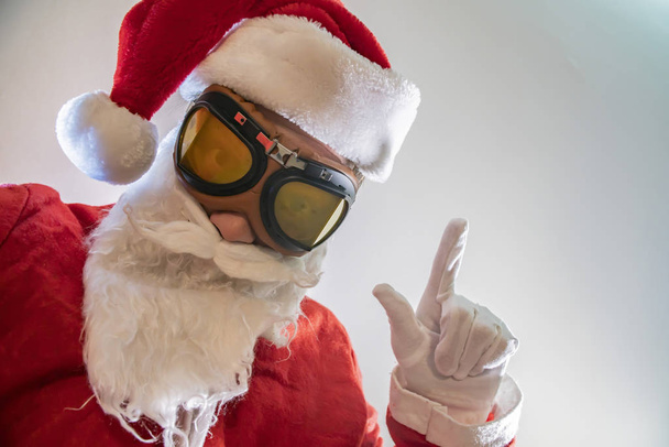 Noel Baba kostümü giymiş sakallı yaşlı bir adamın portresi komik suratını buruşturuyor. - Fotoğraf, Görsel