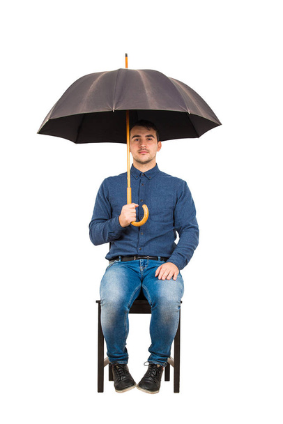 Tuolilla seisovan itsevarman liikemiehen koko pituus
 - Valokuva, kuva