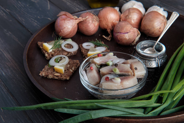 Sliced Scandinavian herring with onion and brown bread - 写真・画像