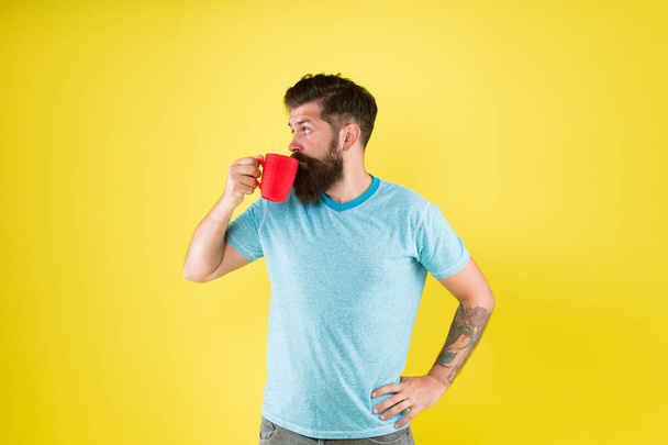Hipster tastes and aesthetics. Energy concept. Hipster barista yellow background. Coffee shop. Bearded man drink morning coffee. Tea time. Cortado with right proportion of milk. Coffee revolution - Photo, image