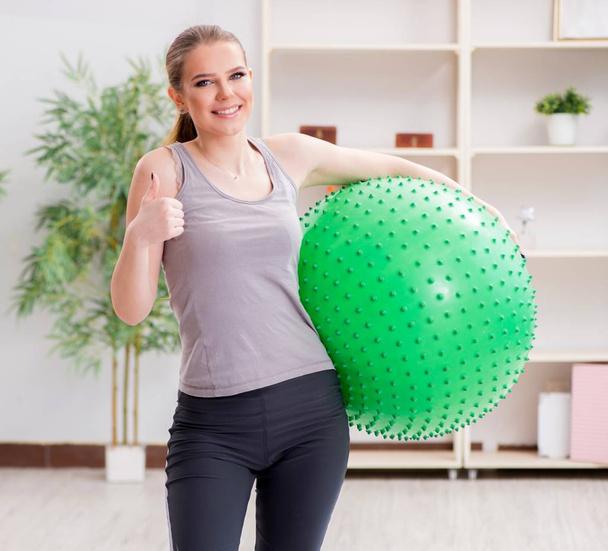 Mladá žena cvičení se stabilitou míč v tělocvičně - Fotografie, Obrázek