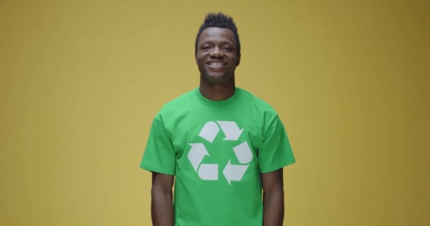 Homem de pé firme enquanto vestindo t-shirt com símbolo de reciclagem
 - Filmagem, Vídeo