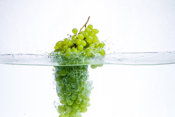 druiven in water. er zweeft water en fruit in.. - Foto, afbeelding