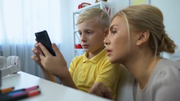 Cute boy showing mother new smartphone application, modern technologies, gadgets - Video