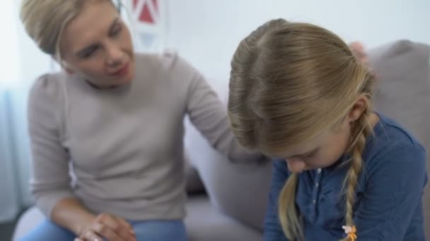 Caring mother comforting and hugging little sad daughter school bullying problem - Imágenes, Vídeo