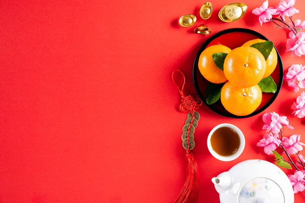 Chinese nieuwjaar festival decoraties pow of rood pakket, oranje en gouden ingots of gouden brok op een rode achtergrond. Chinese karakters FU in het artikel verwijzen naar geluk, rijkdom, geldstroom. - Foto, afbeelding