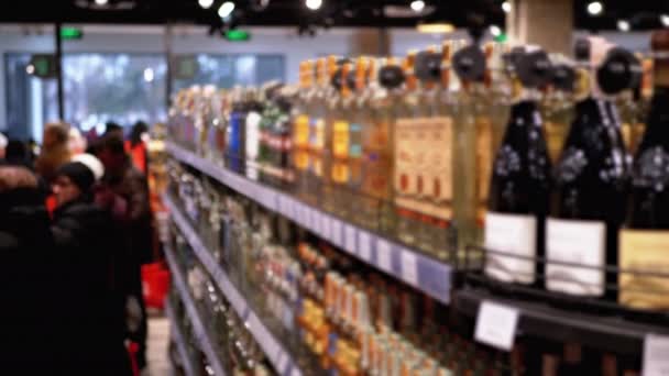 Prodej alkoholu v supermarketu. Řádky a police s lahvovým alkoholem v okně obchodu - Záběry, video