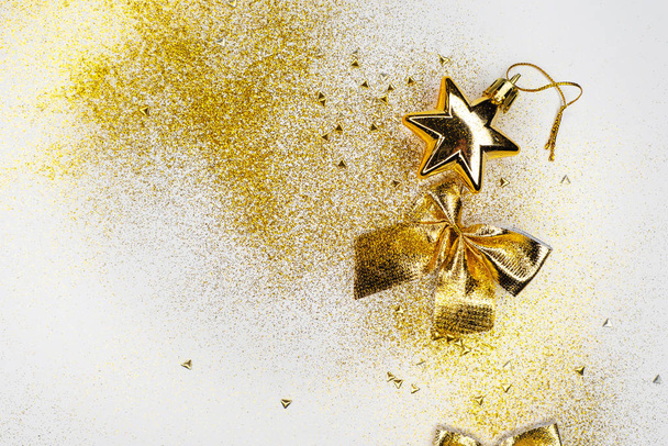 Şenlikli yeni yıl yatışı. Beyaz arka planda altın dekoru. Parlak tatil fiyonkları, boncuklar ve hediye kutuları - Fotoğraf, Görsel