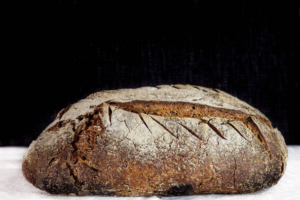 Loaf (or miche) of French sourdough, called as well as Pain de campagne, on display on a black and white background. Pain de Campagne is a typical French huge loaf of bread abiding by traditional codes - Фото, изображение