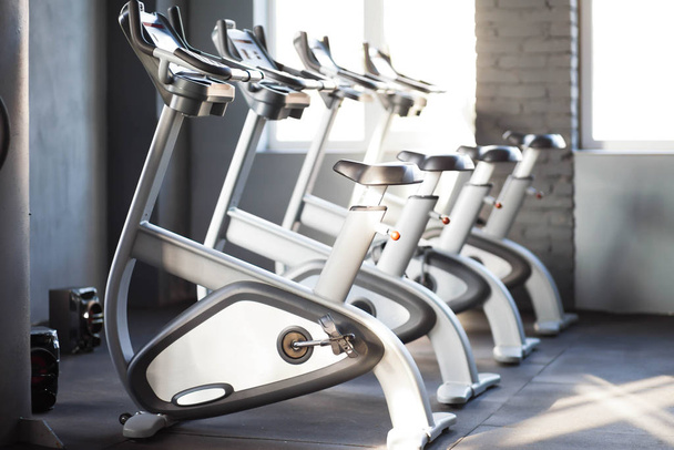 Many exercise bikes in the gym. Gym equipments interior. Slimming equipment - 写真・画像