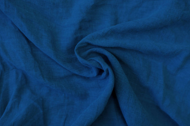 Crumpled blue fabric texture close up. Trendy tone of 2020 classic blue color - Photo, image