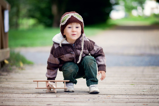 Autumn portrait of a boy with airplane in a park - 写真・画像