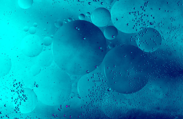 Macro shot of water oil emulsion over colored background - Photo, Image