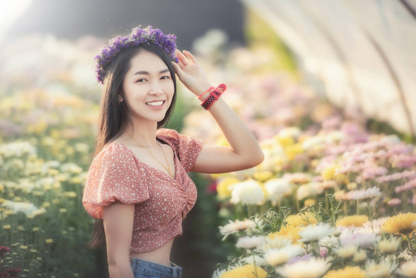 Çiçek tarlasına bakan güzel genç kadın gezgin.  - Fotoğraf, Görsel