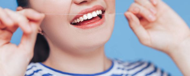 Женщина улыбается зубной нитью
 - Фото, изображение