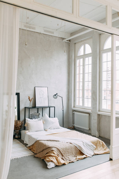 Bright photo Studio with a bed and a window. Stylish modern loft interior.  - Фото, изображение