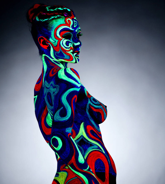 Body art. Portrait of nude girl posing in UV light - Valokuva, kuva