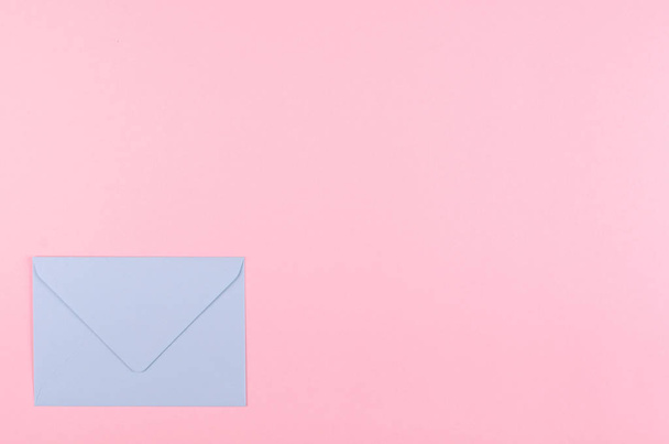 Blue paper envelope composition on pink background. - Foto, afbeelding
