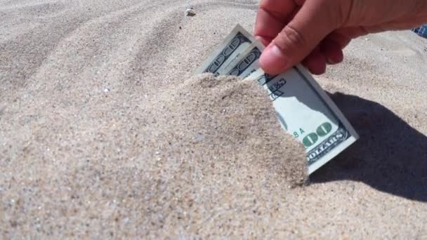 Ένα κορίτσι παίρνει από την άμμο χαρτονομίσματα των τριακοσίων δολαρίων - Πλάνα, βίντεο