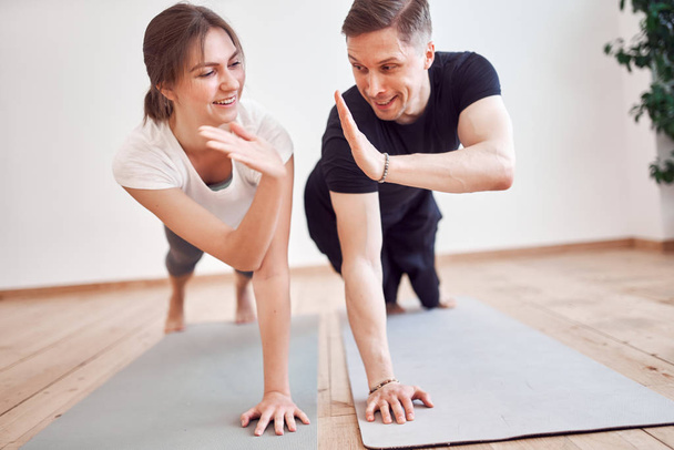 Athletic woman and man doing handshake on sports mat - Photo, Image