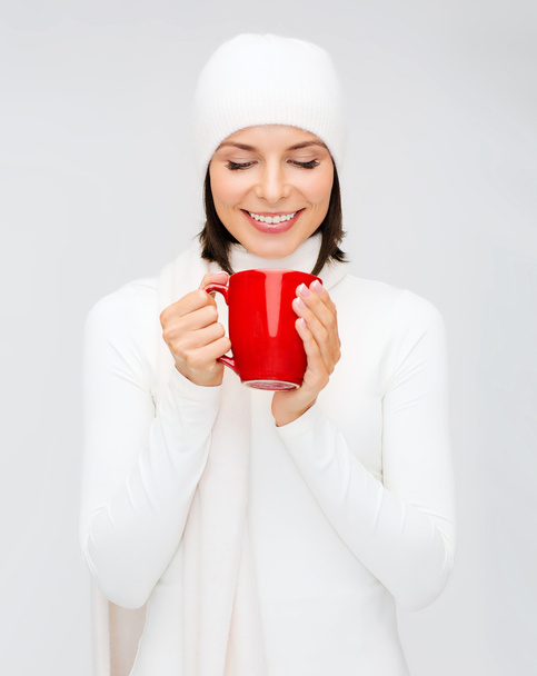 Woman in hat with red tea or coffee mug - Фото, зображення