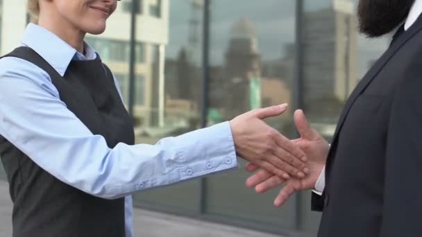 Женщина-босс пожимает руку партнеру-мужчине, пытается поцеловать женскую руку, недовольство
 - Кадры, видео