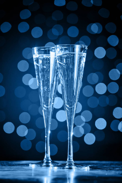 zwei Gläser Champagner auf klassischem blauem Bokeh-Hintergrund - Foto, Bild