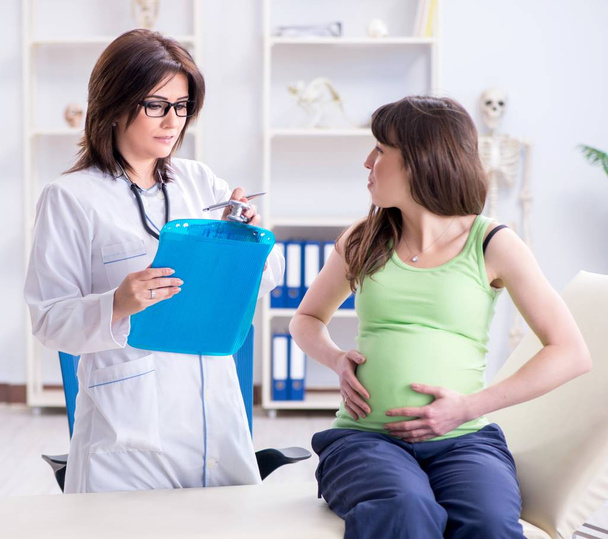 Zwangere vrouw op bezoek bij arts voor regelmatige controle - Foto, afbeelding