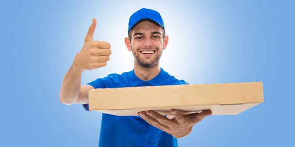 dostawca pizzy uśmiecha się z okay znak na niebieskim tle - Zdjęcie, obraz