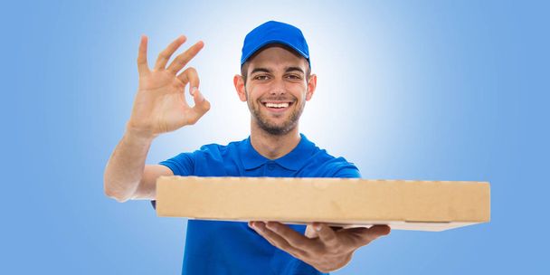 pizza toimitus mies hymyilee kunnossa merkki sinisellä taustalla
 - Valokuva, kuva