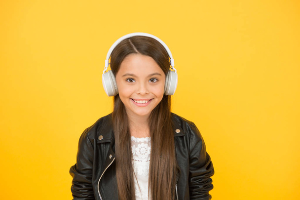 Enjoying every note. Musical education. Music creation and distribution. Musical taste. Musical accessory. Gadget shop. Small girl listening music wireless headphones. In love with stereo sound - Foto, Bild
