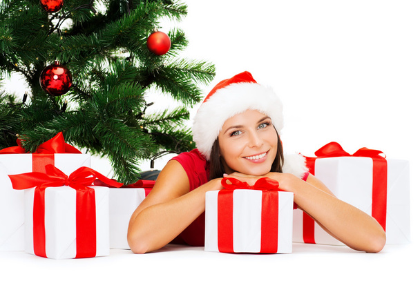 Smiling woman in santa helper hat with gift boxes - Foto, afbeelding