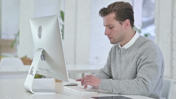 Shocked Creative Young Man Reacting to Failure on Desktop - Кадри, відео