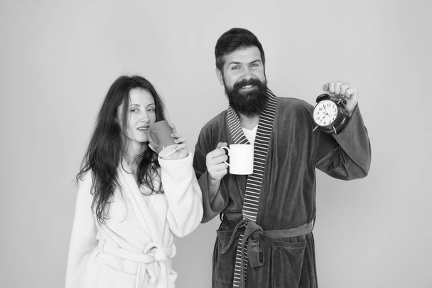 start a healthy morning. time to love. tea time at home. hard morning. morning couple drink coffee. bearded man and girl coffee cup. wake up time. family life routine. couple in love alarm clock - Foto, immagini
