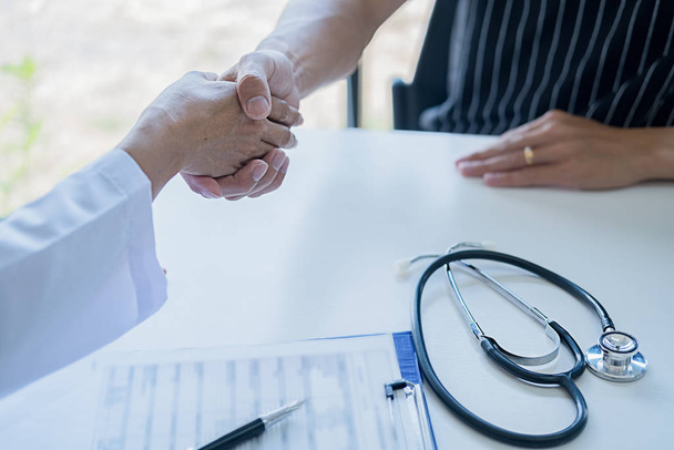 Dokter en patiënt schudden elkaar de hand. Partnerschap in de geneeskunde - Foto, afbeelding