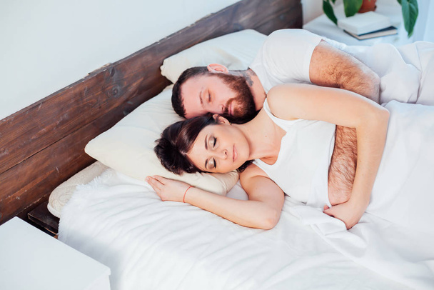 mies ja nainen nukkuvat sängyssä kotona
 - Valokuva, kuva