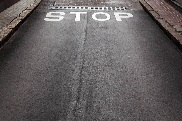 Señal de stop blanco sobre asfalto negro en el suelo
 - Foto, imagen