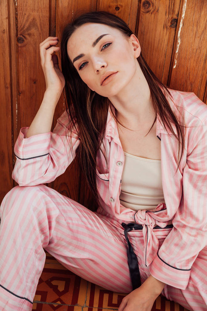 mooie vrouw in roze pyjama in de slaapkamer - Foto, afbeelding