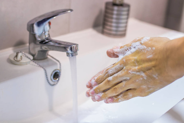 ruce v umyvadle s vodou z kohoutku a mýdlem - Fotografie, Obrázek