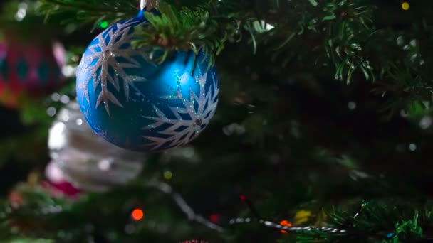 Christmas Miracle is Coming. Christmas tree branches decorated with bright sparkling garlands and Christmas decorations are slowly moving in front of the camera - Filmati, video