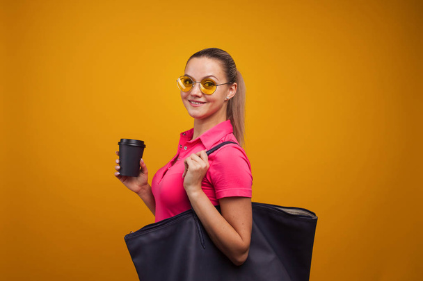 Business positive girl in casual style hurries on business and drinks coffee to take away. Coffee break - Foto, afbeelding