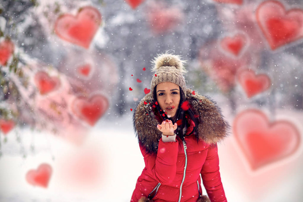 φυσάει φιλιά. Γυναίκα σε χιονισμένο χειμώνα. Το κορίτσι απολαμβάνει το χιόνι. - Φωτογραφία, εικόνα
